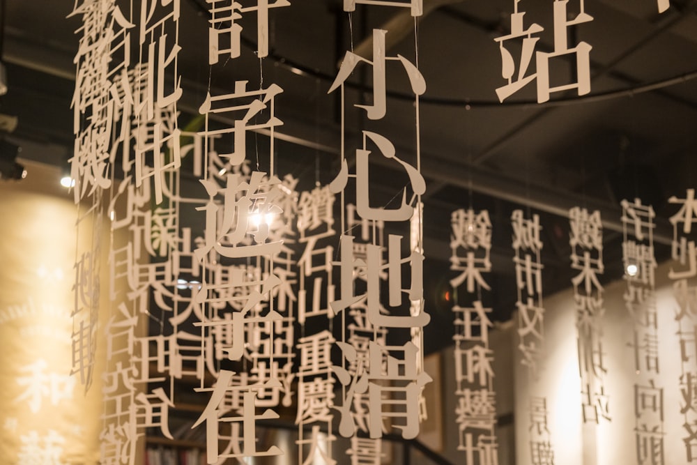 a number of chinese characters hanging from a ceiling