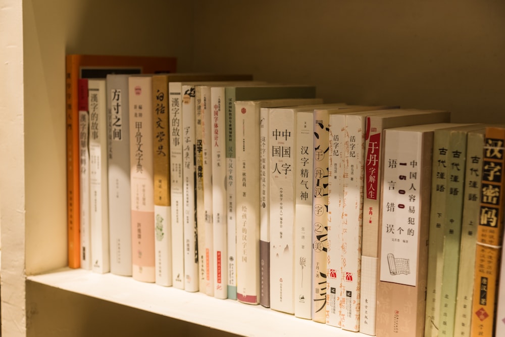 a row of books sitting on top of a white shelf