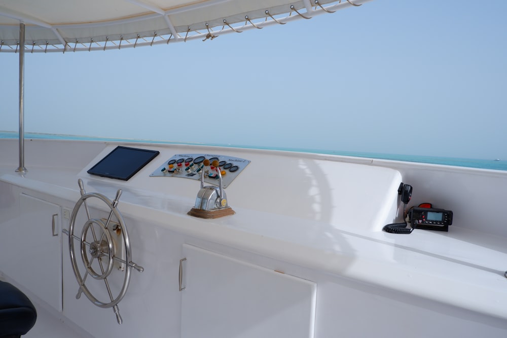 a white boat with a steering wheel and a tablet