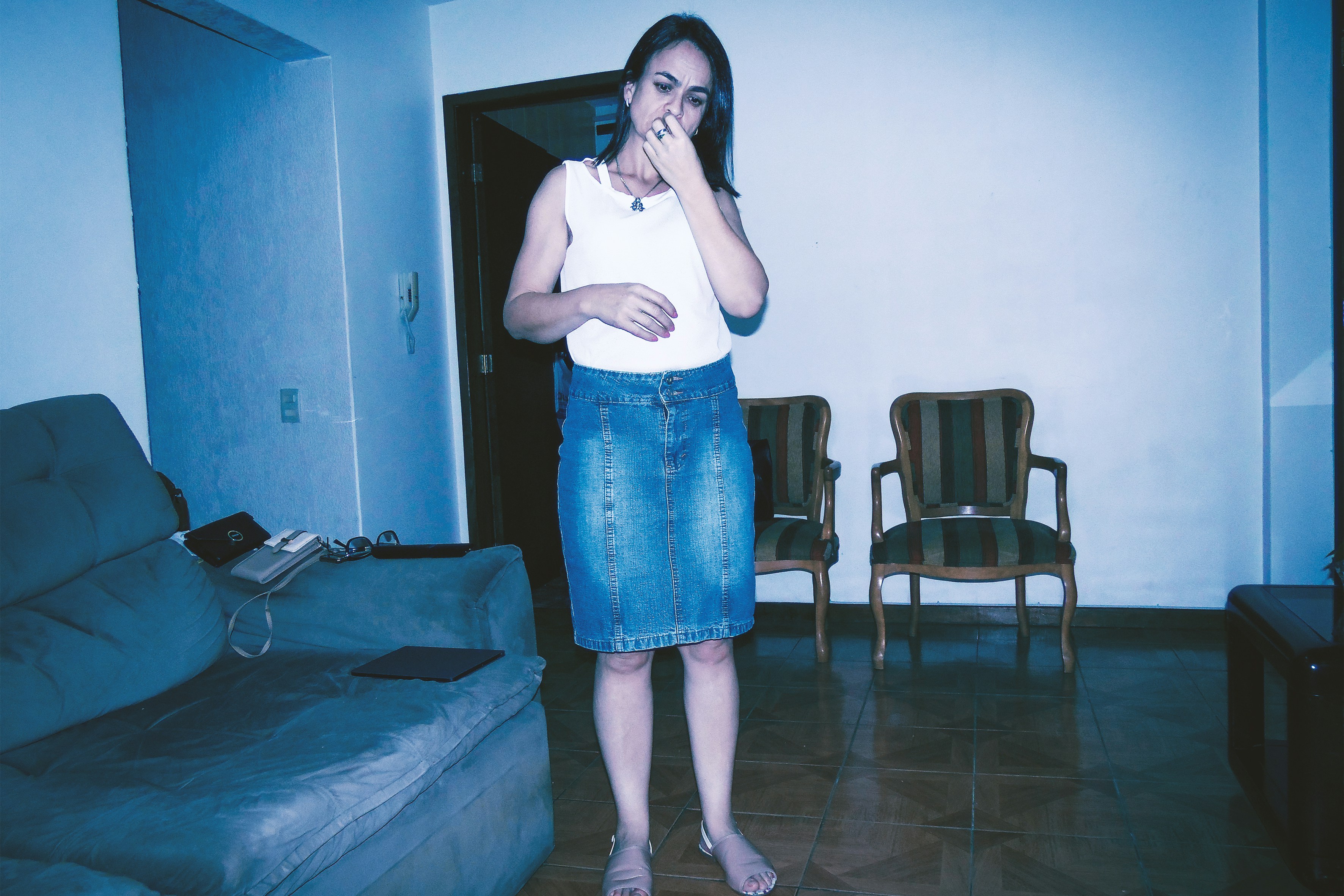 Fotomural a woman standing in a living room brushing her teeth