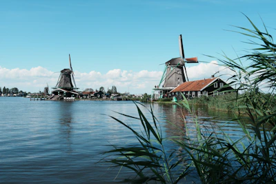 a couple of windmills sitting on top of a lake