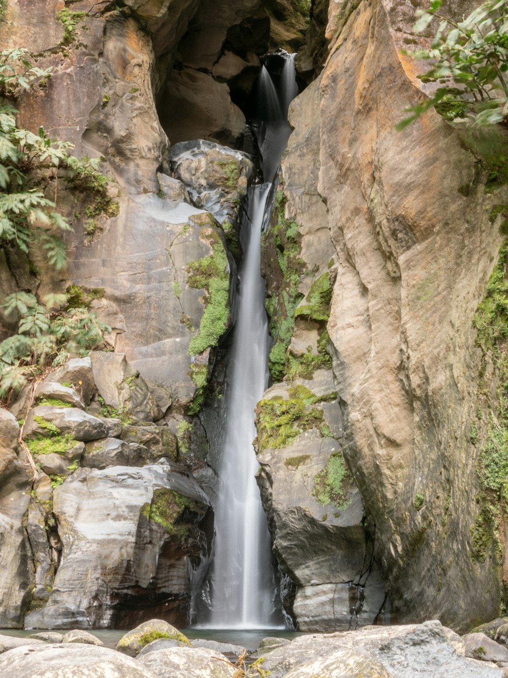 a waterfall is coming out of a cave