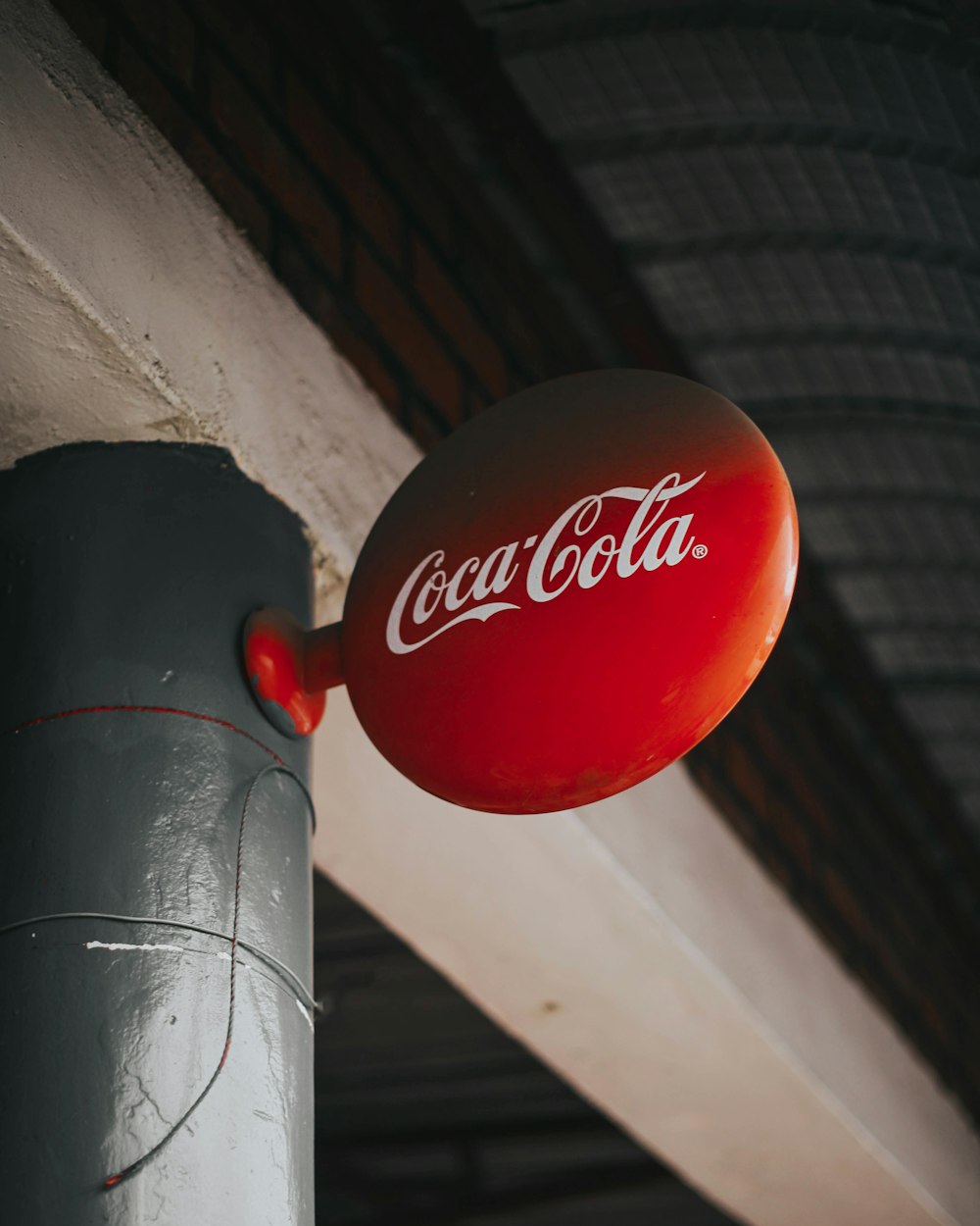 a close up of a coca cola sign on a pole