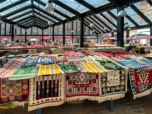 A market with a lot of colorful rugs on display — Tirana, Albania