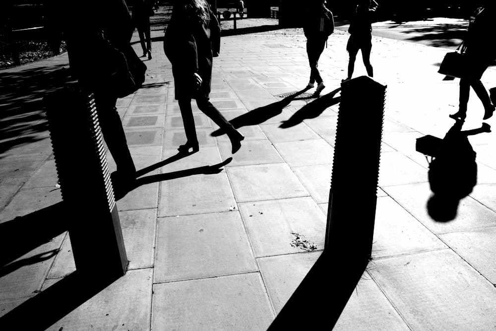 a group of people walking down a sidewalk