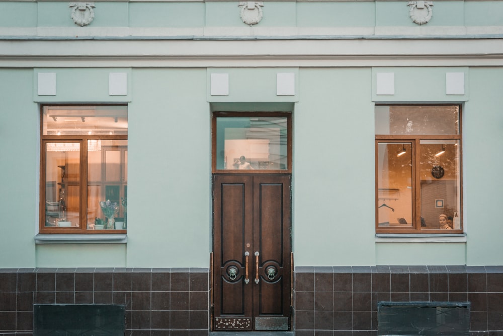 a building with a brown door and two windows