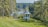 a white gazebo sitting on top of a lush green field