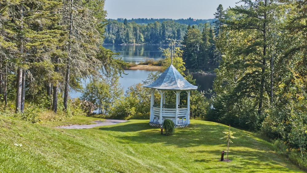 a white gazebo sitting on top of a lush green field