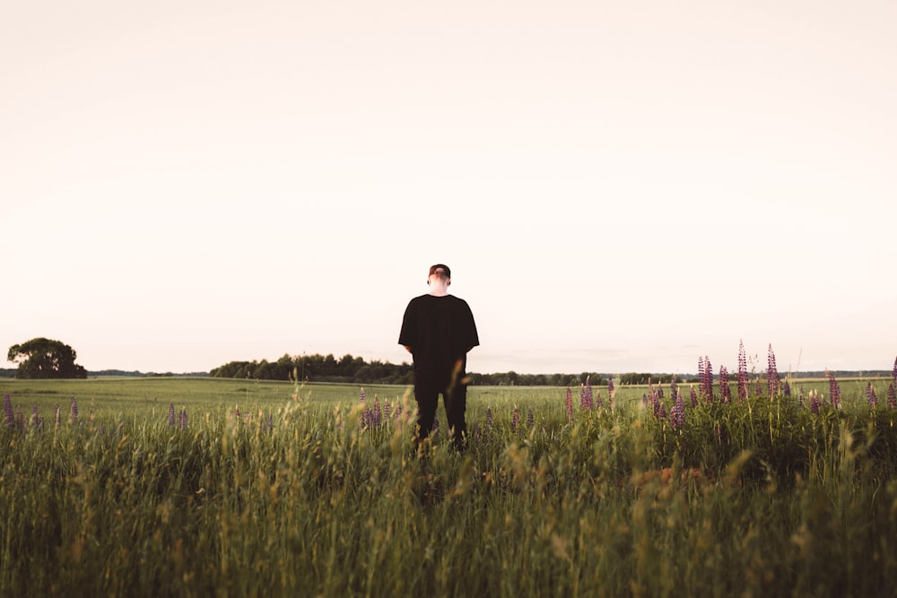 a man standing in a field of tall grass