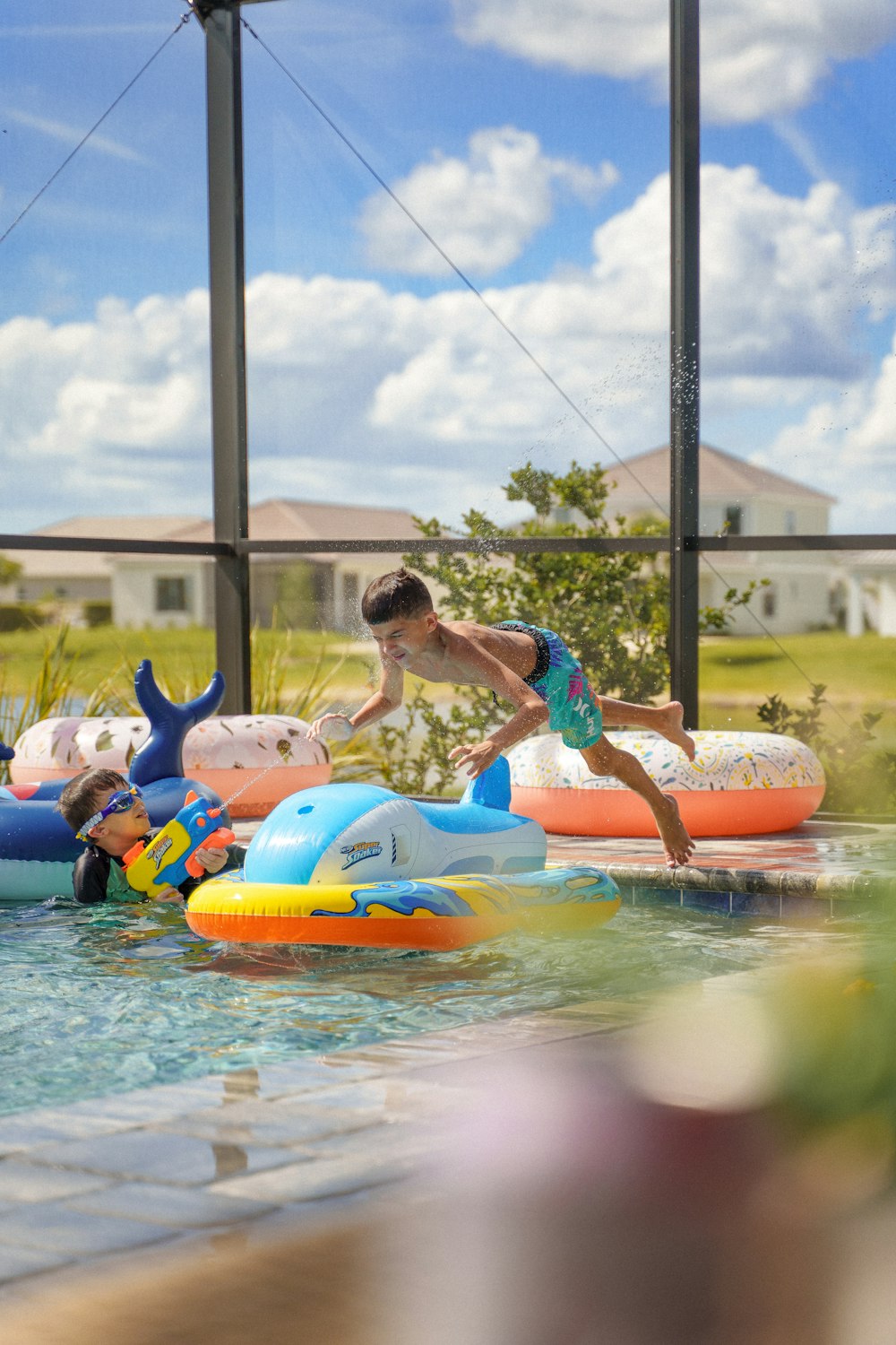 a boy is playing in a pool with inflatable toys
