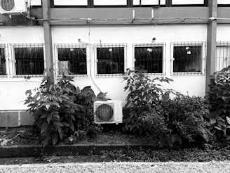 a black and white photo of an air conditioner in front of a building