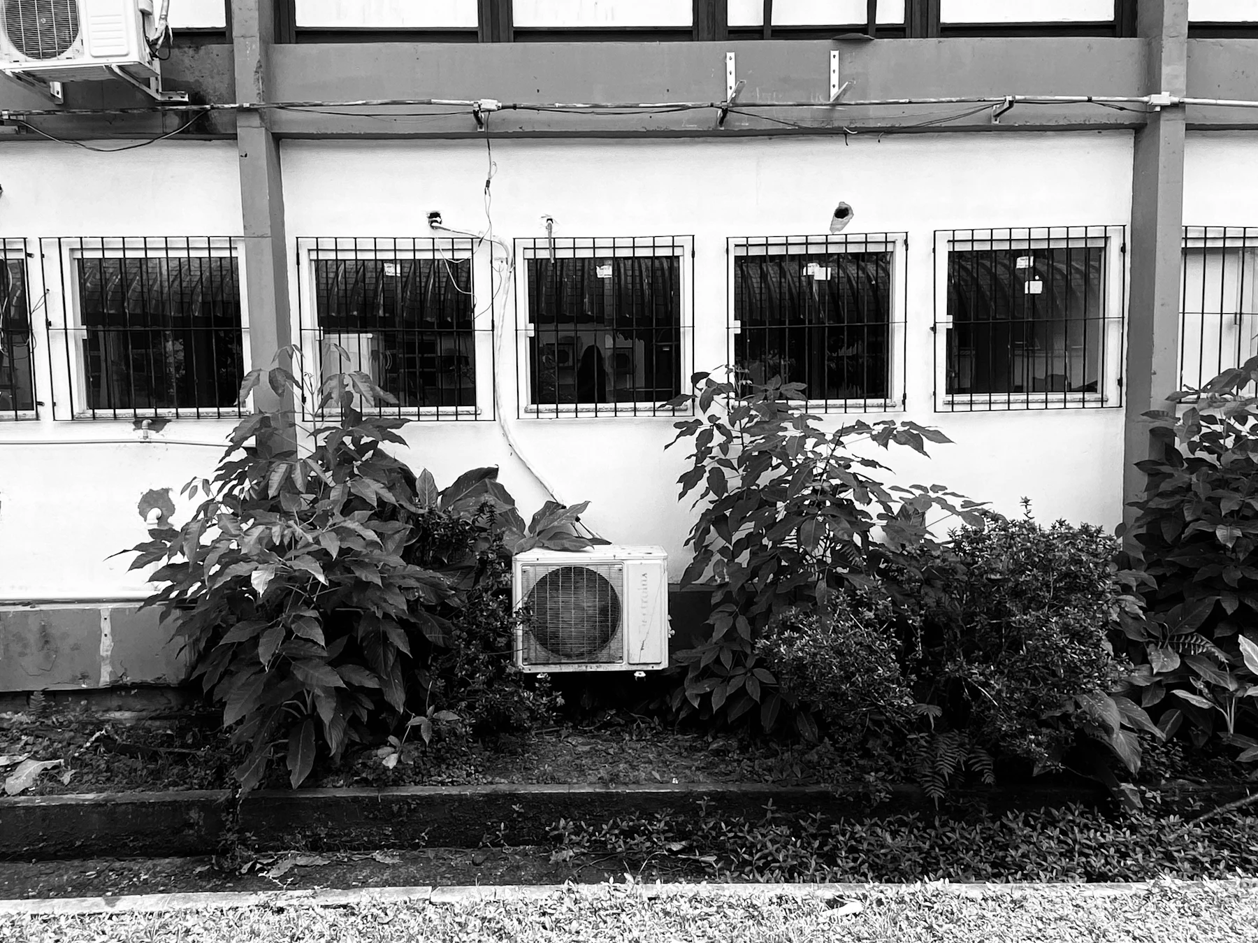 black and white photo of an AC unit in front of a building