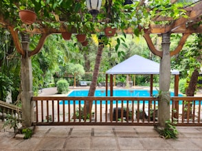 a gazebo with a pool in the background