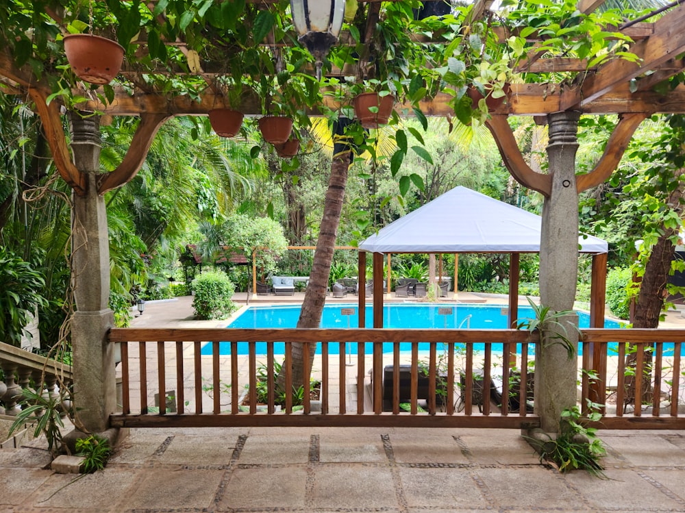 a gazebo with a pool in the background