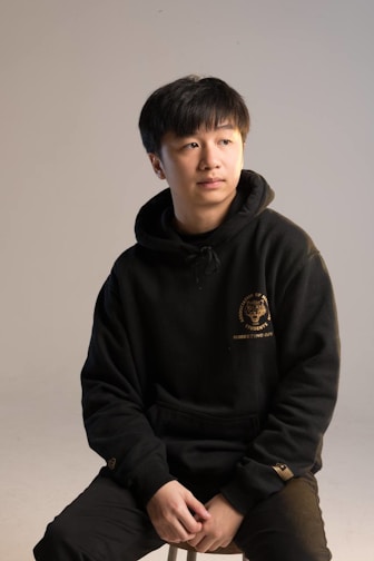 Minimalist black hoodie with subtle rebellious embroidery detail.