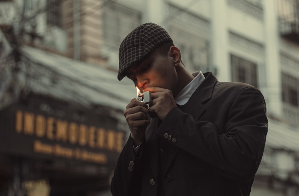 a man standing in front of a building holding a cigarette