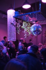 A vibrant party room decorated with glowing purple and blue space-themed lights and starry decorations.