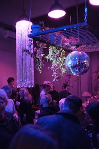 A vibrant party room decorated with glowing purple and blue space-themed lights and starry decorations.