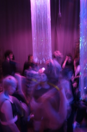 A vibrant and elegant event venue with mood lighting and guests enjoying drinks.