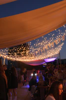 An intimate private party setup with warm lighting and guests mingling around stylish decor.