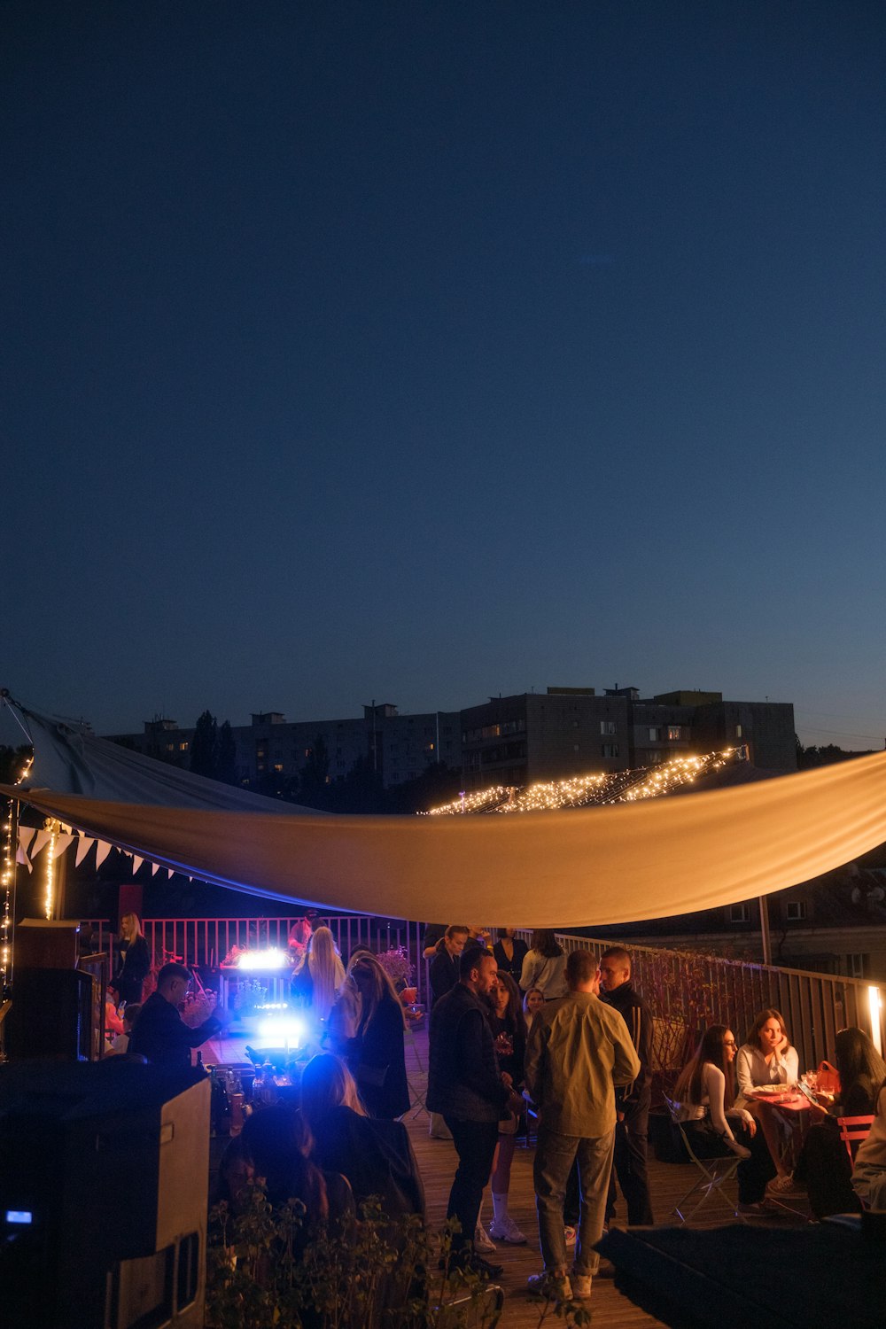 a group of people gathered under a tent at night