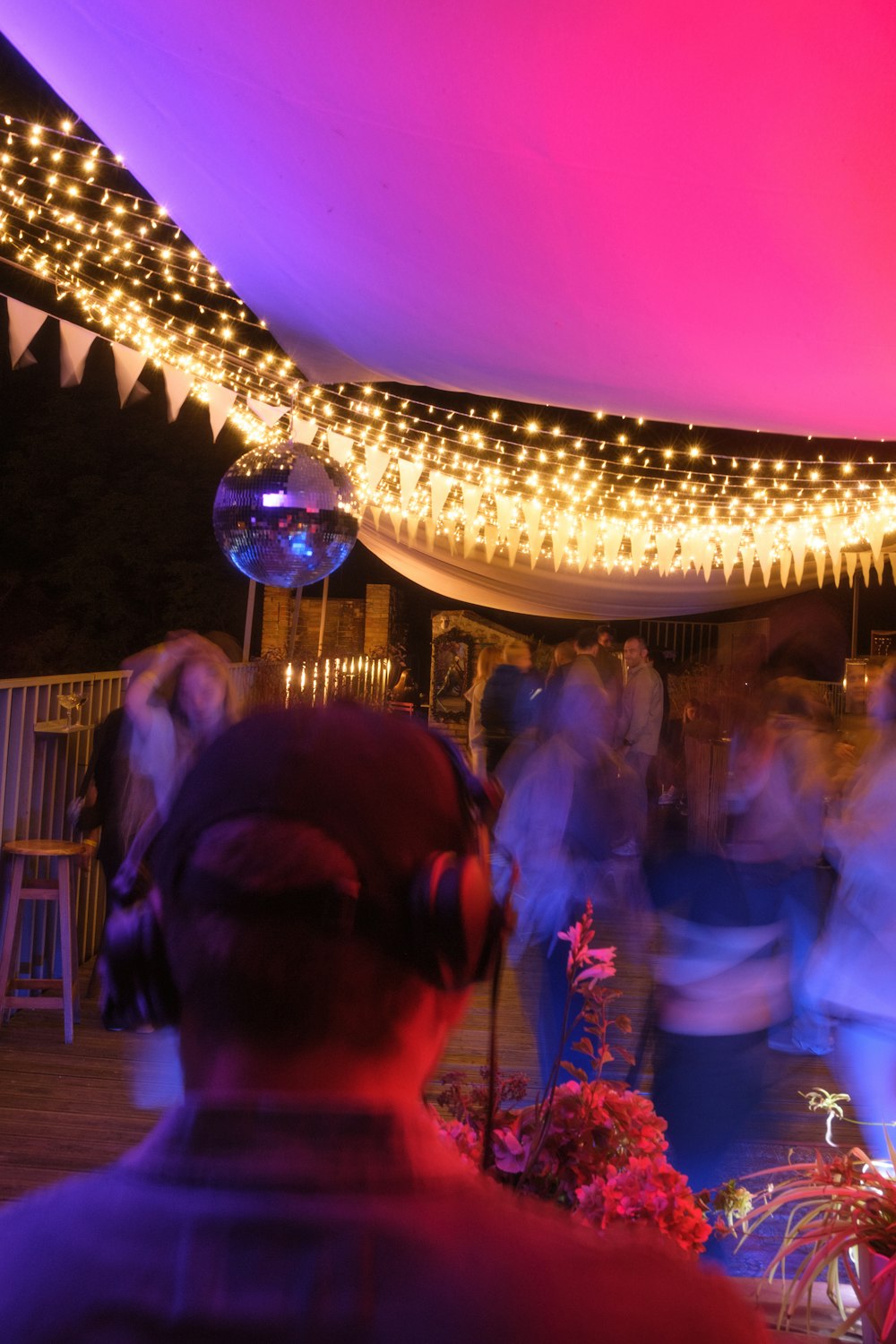 a group of people standing under a tent covered in lights