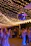 A lively crowd dancing under colorful lights at an outdoor graduation party.