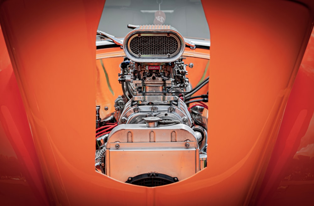 Der Motorraum eines orangefarbenen Sportwagens