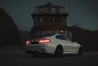 a white car parked in front of a building