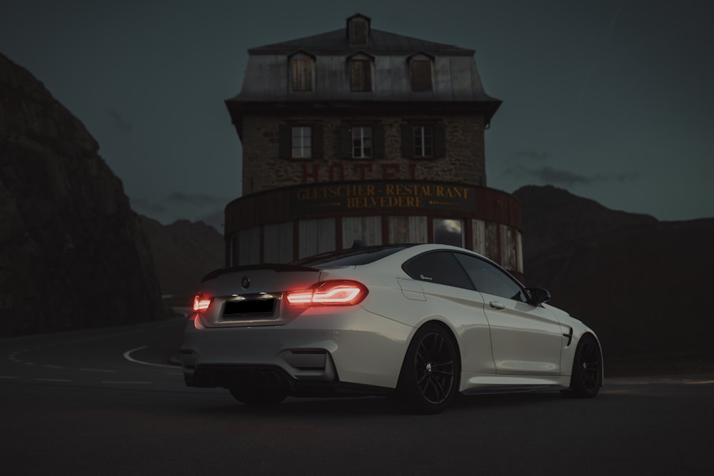 a white car parked in front of a building