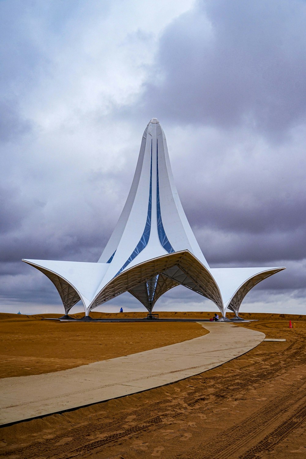 a large white structure sitting on top of a dirt field