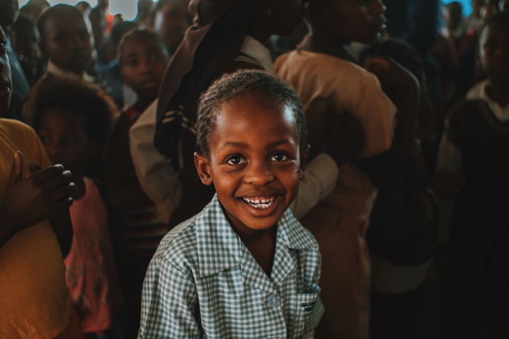 a young boy smiling in front of a group of people