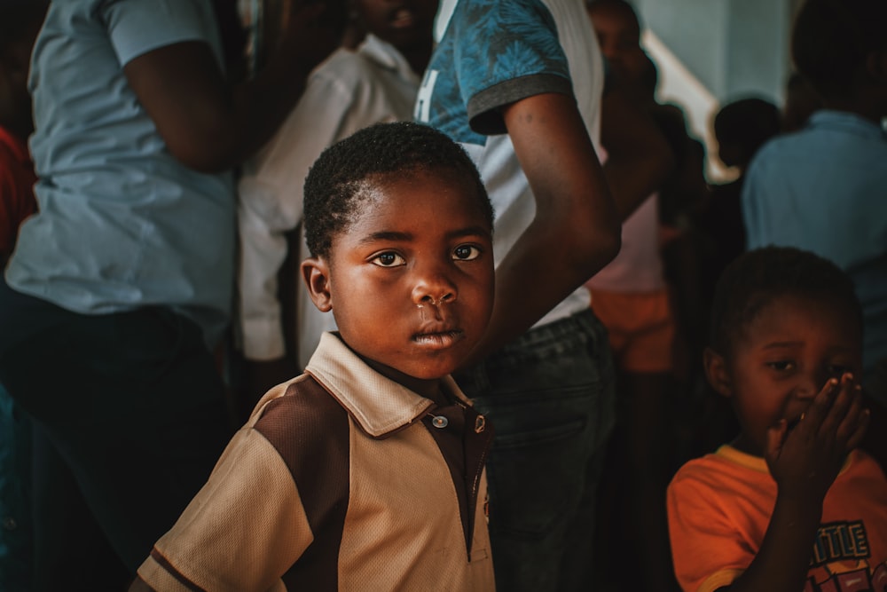 a young boy standing in front of a group of people