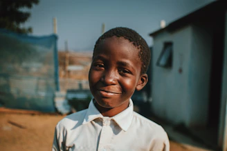 A young boy smiling after a neat school haircut in a cozy home setting.