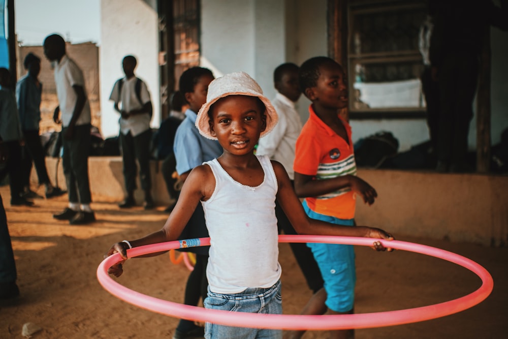 a young girl holding a pink hula hoop
