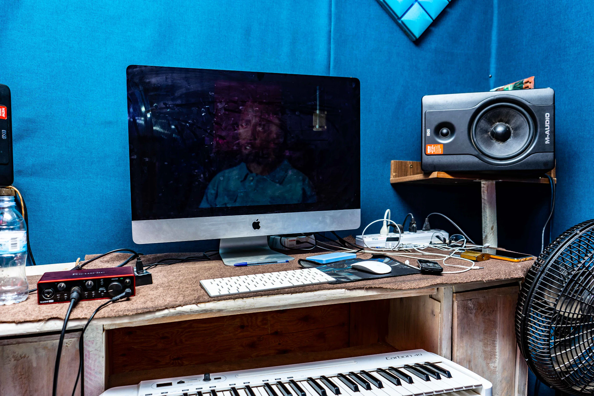 A minimalist desk scene showcasing neatly arranged audio gear, including cables, earbuds, and a compact audio interface under cool blue LED lights.