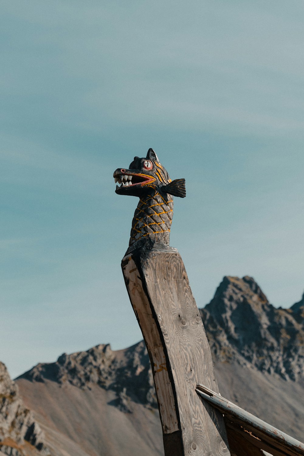 a wooden sculpture of a person on top of a mountain