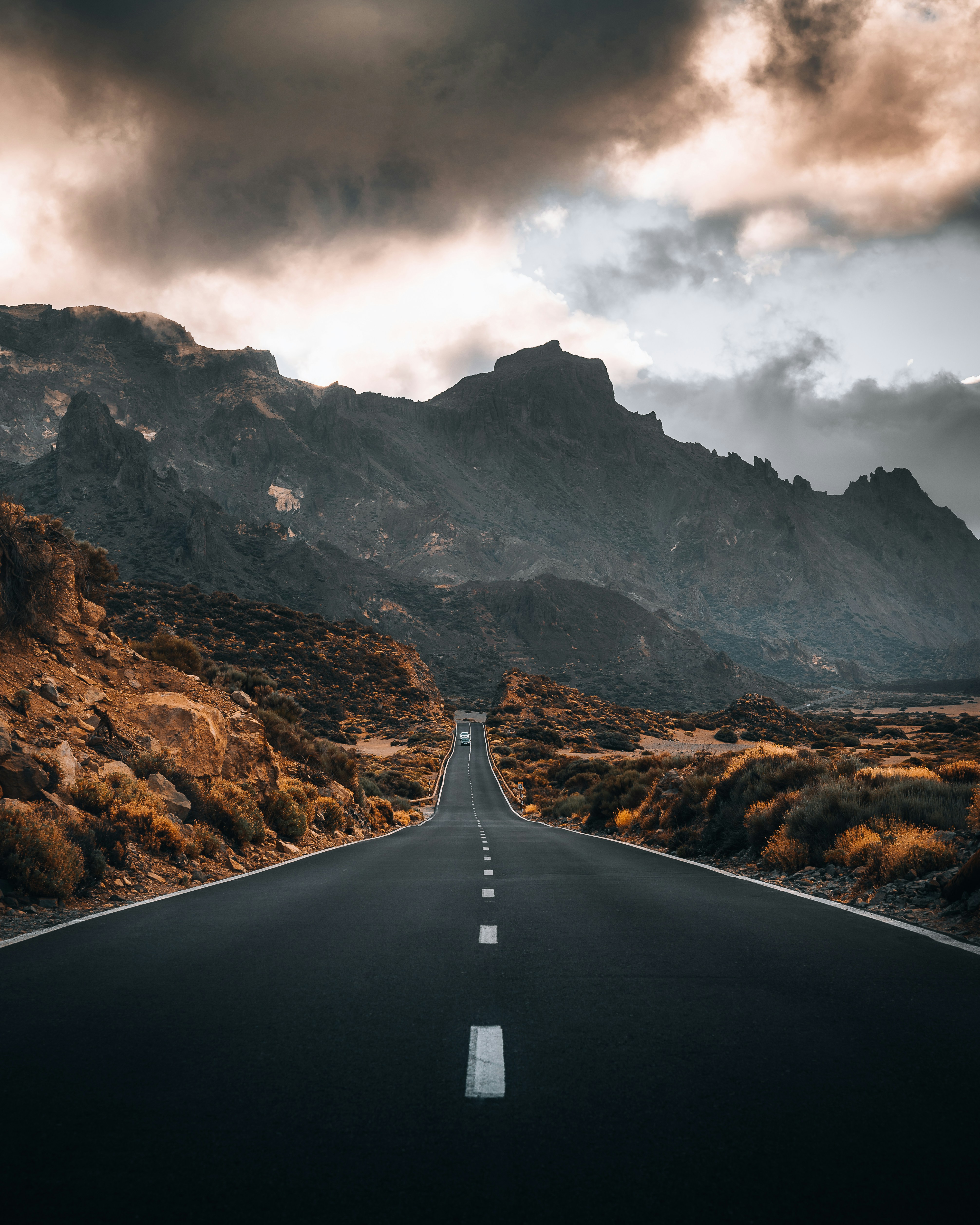 Un largo camino recto con una montaña al fondo