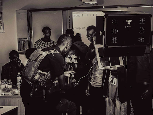 A diverse group of extras waiting on set, chatting and preparing for a film shoot.