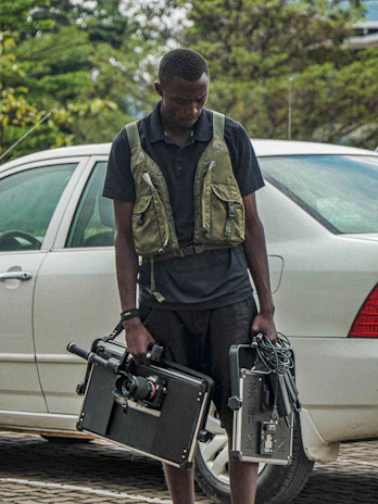 An influencer filming a dynamic car review with professional camera gear beside a modern SUV.