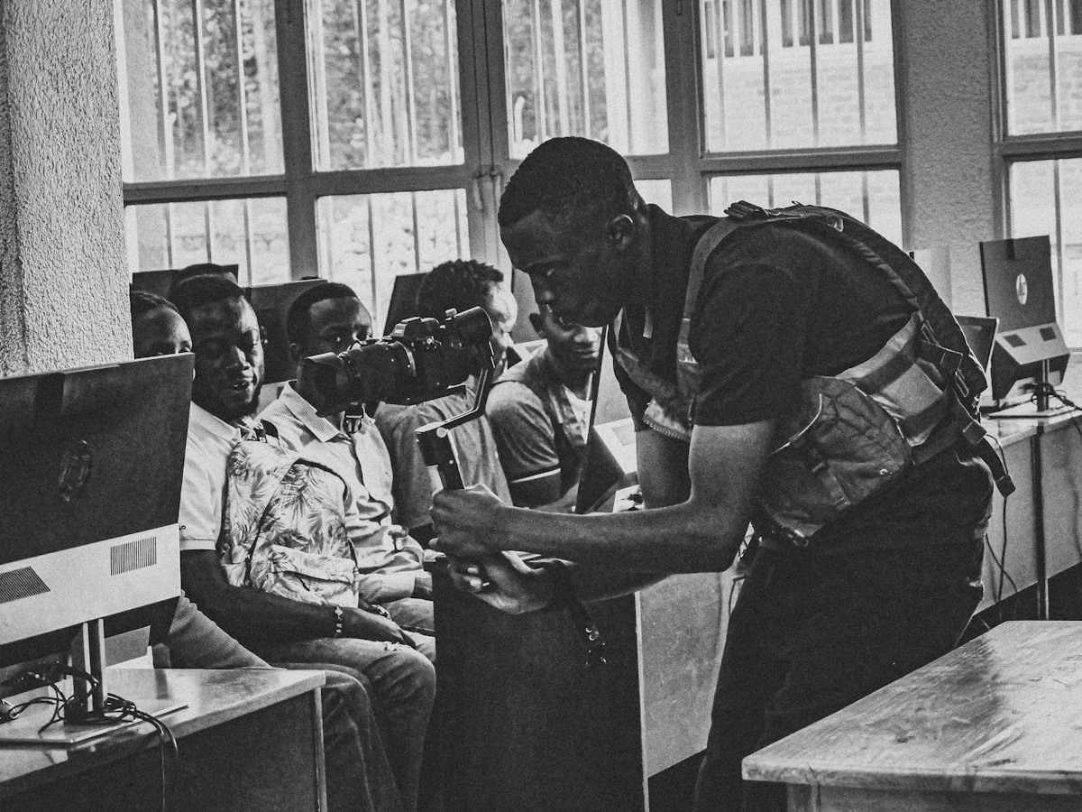 A black and white photo of a man looking at a computer