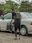 Smiling man standing next to his car with a Voltaris battery box in hand.