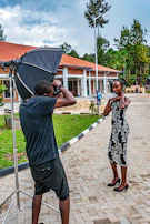 Fashion model posing outdoors with minimalist architectural background under soft natural light.