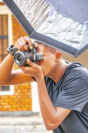 A photographer holding a compact mirrorless camera, ready to capture a moment outdoors.