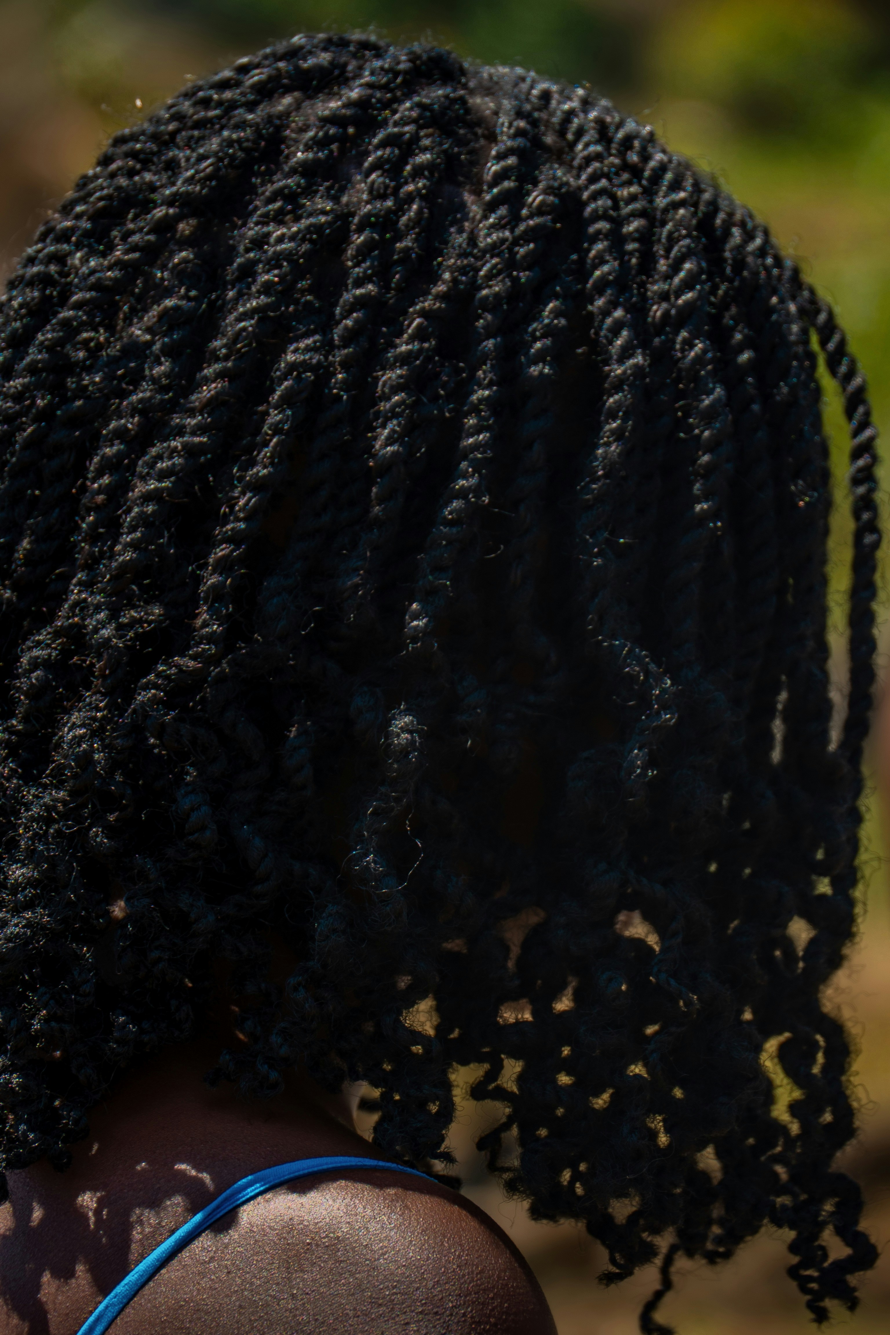 Micro braids hairstyle close-up, dark studio atmosphere, deep shadow contrast, moody tones