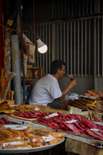 Close-up of artisanal smoked trout and gourmet pack with local Malaga products on rustic wooden table
