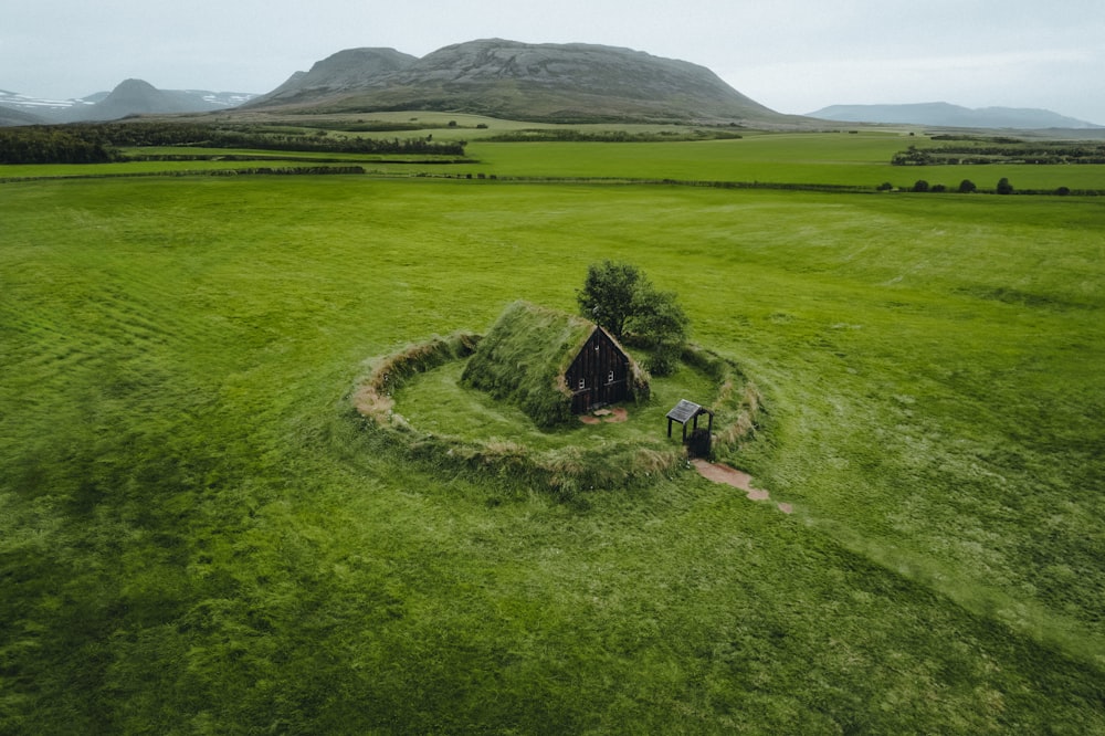 an aerial view of a small house in a field