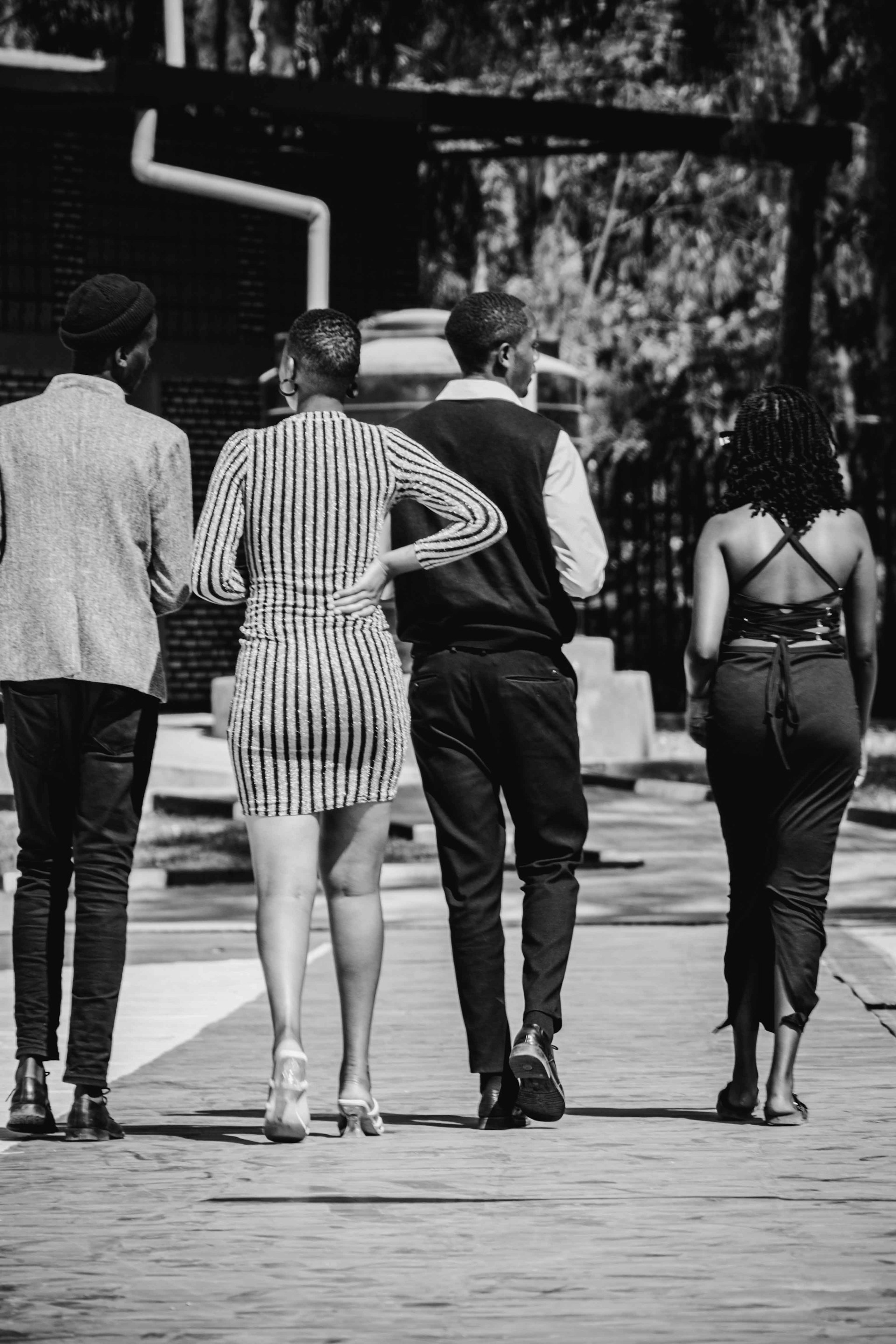 Monochrome video clip showing a group of friends walking in minimal casual clothing, with soft grey tones.
