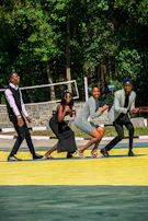 Group of friends laughing and playing on a court surrounded by vibrant street art.