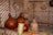 A rustic interior is adorned with intricately woven straw mats on the walls and several large, traditional earthenware pots and gourds on wooden shelves. Basketry and a hat are mounted as decorations.